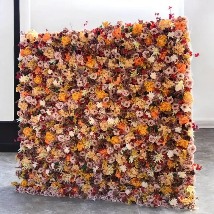 Side angle of fall-themed floral wall featuring orange, mauve, and cream flowers.