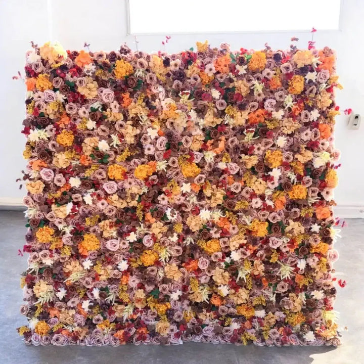 Rustic flower wall with warm-toned roses, marigolds, and fall foliage.