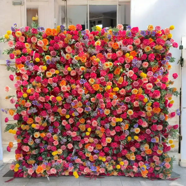 Bright flower wall with pink, orange, yellow, and purple roses for party or wedding use.