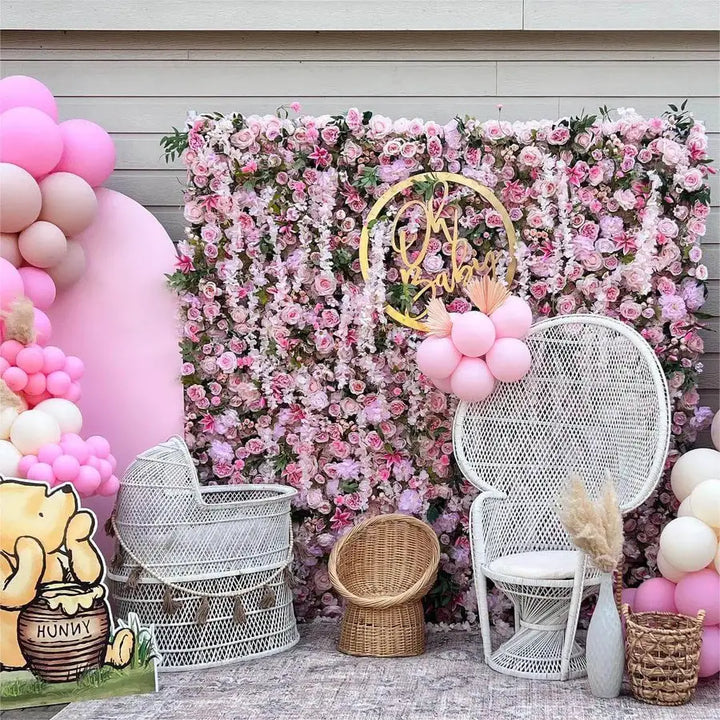 Lush decorative flower wall with pink flowers and greenery for elegant gatherings.