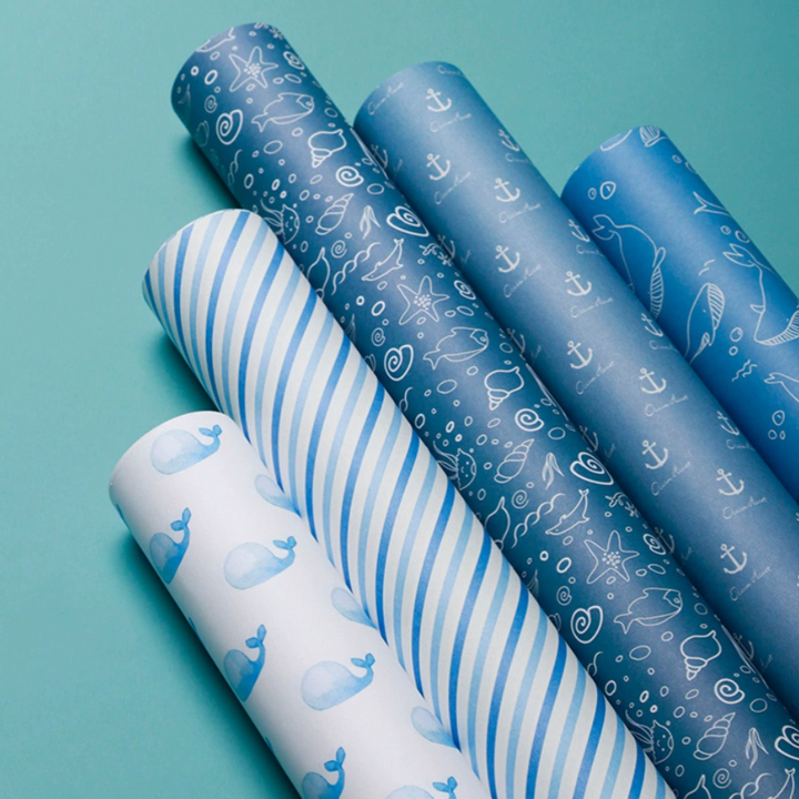 Blue ocean-themed wrapping paper with whale patterns.