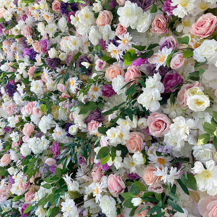 Side view of lush floral backdrop featuring roses, daisies, and rich green leaves.
