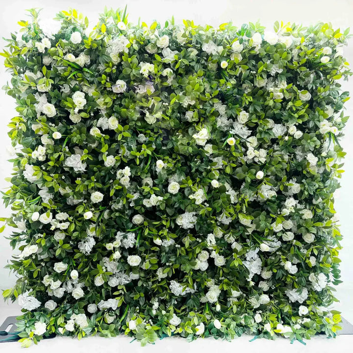 Close-up of white blooms on green leafy flower wall backdrop.