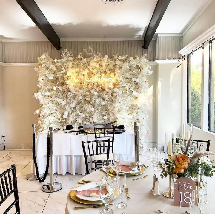 Close-up of white roses and soft champagne accents on luxury flower wall.