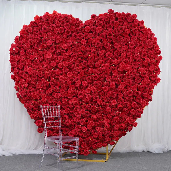Heart-shaped red floral backdrop at a wedding venue with a clear chair.