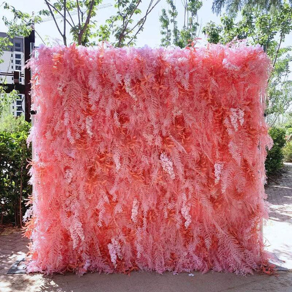 Pink feather-like flower wall backdrop in an outdoor setting, perfect for events.