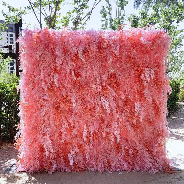 Pink feather-like flower wall backdrop in an outdoor setting, perfect for events.