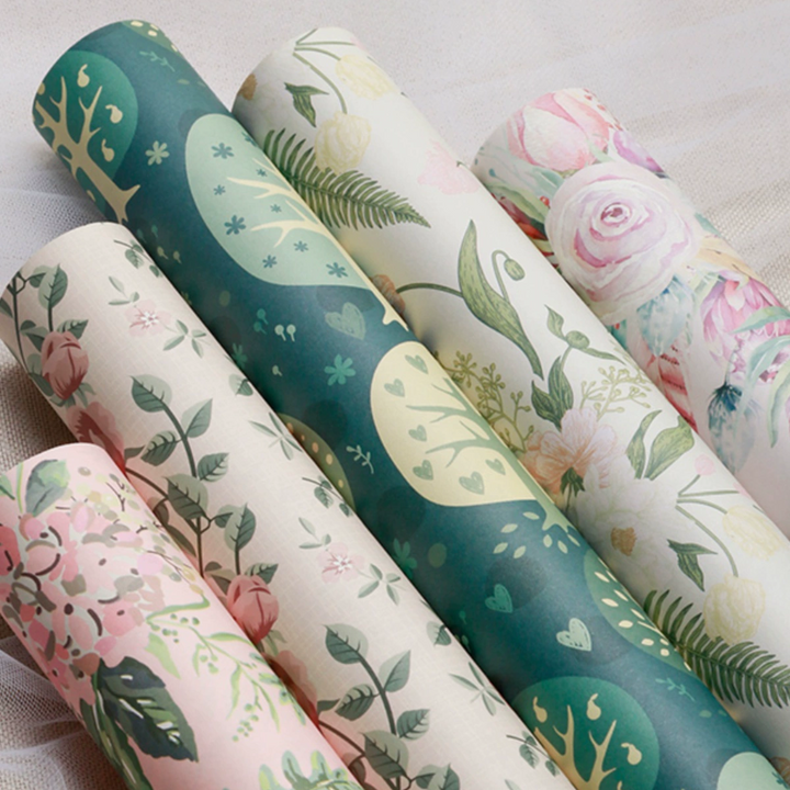 Floral wrapping paper with pastel pink roses and greenery.