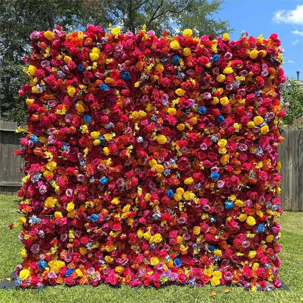 Outdoor setup of colorful multicolor flower wall featuring red, yellow, blue, and pink blooms