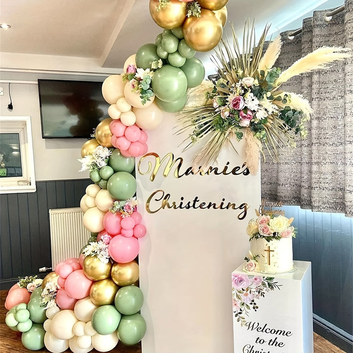 Garden-themed event centerpiece with pink, gold, and green balloon arch
