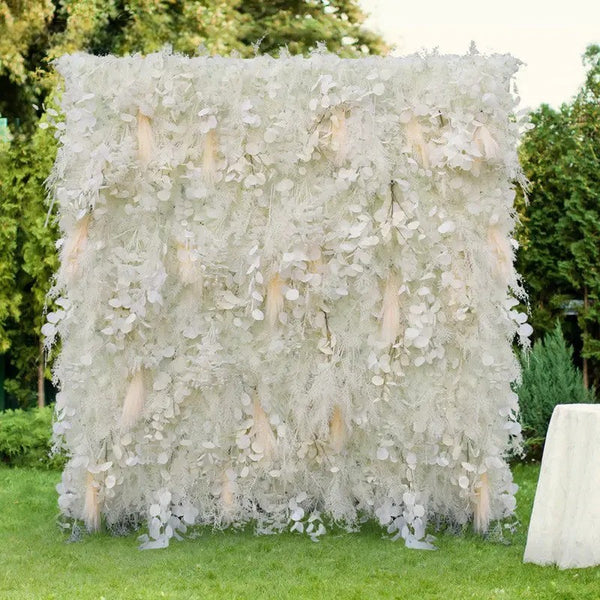 Outdoor setup of a floral backdrop on green lawn with lush trees behind.