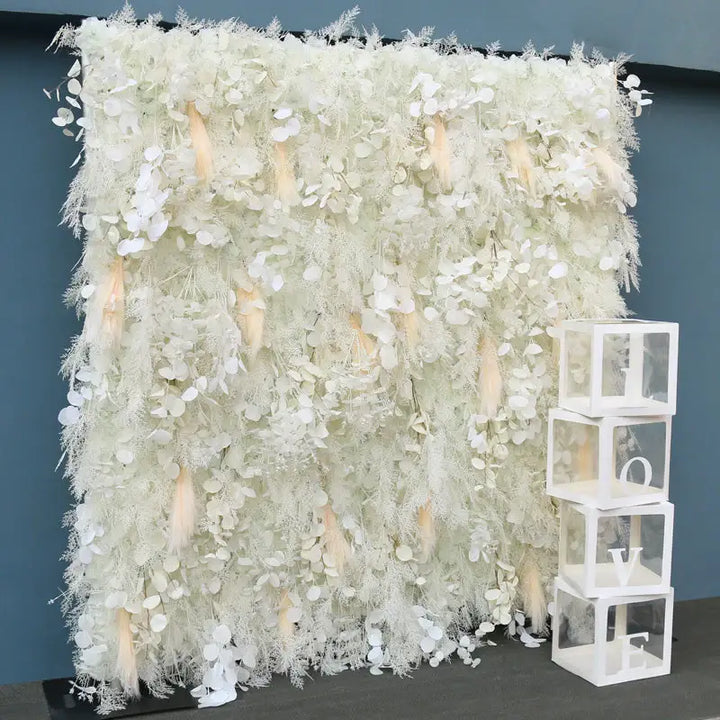 White flower wall with “LOVE” letter cubes, styled for a wedding or party.