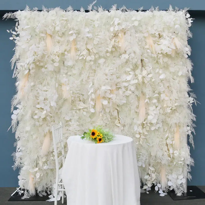 Outdoor setup of a floral backdrop on green lawn with lush trees behind.