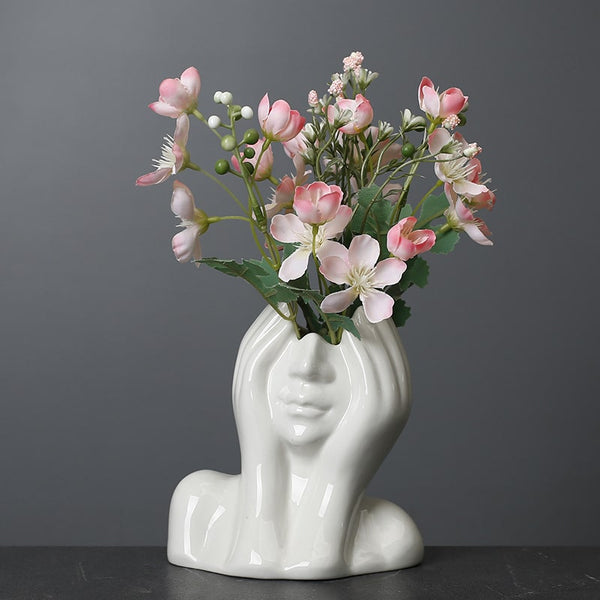 Sculptural Nordic ceramic face vase with floral arrangement