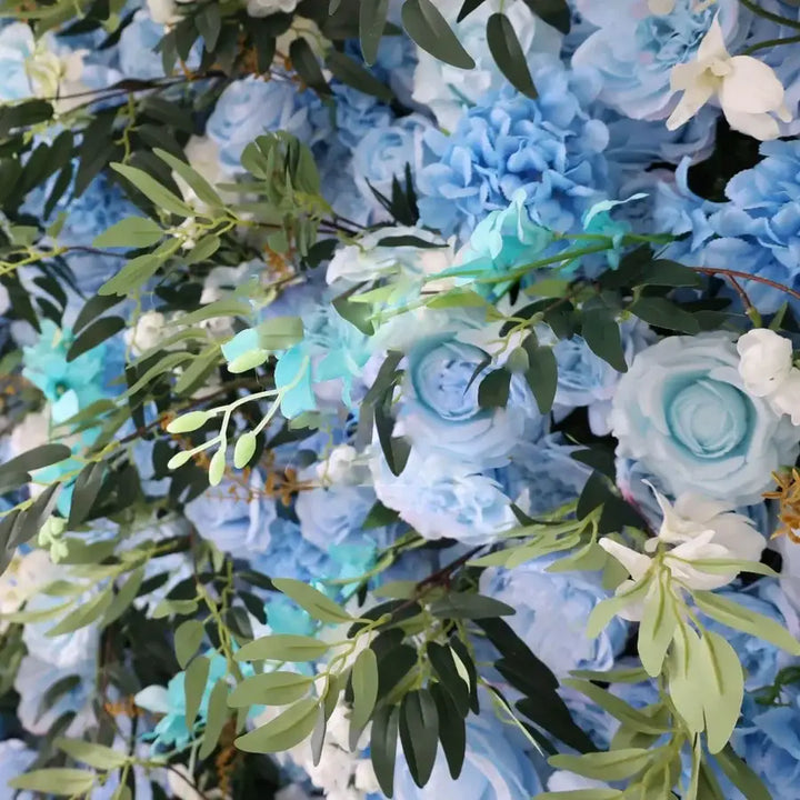 Close-up of blue and green flower wall with roses and greenery for weddings.