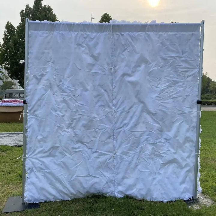 Rear view of flower wall setup with supportive white fabric backing.