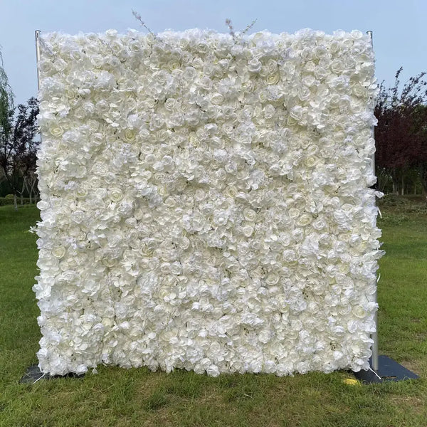 Elegant all-white rose flower wall setup outdoors on green grass.