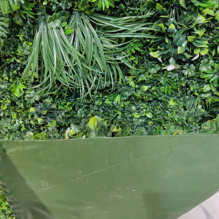 Close-up view of a vibrant green flower wall with foliage for parties and events.