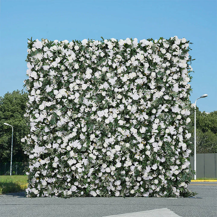 Outdoor floral wall backdrop featuring white blooms and rich foliage.
