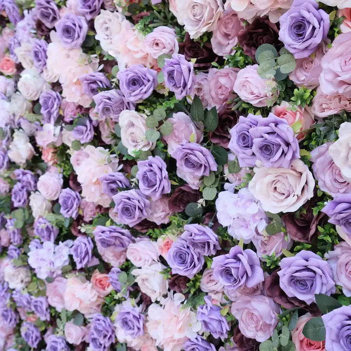 Close-up of purple roses and greenery in a decorative flower wall for events.