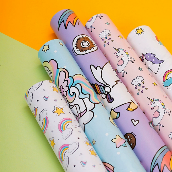 Unicorn-themed gift wrapping paper with rainbows and stars.