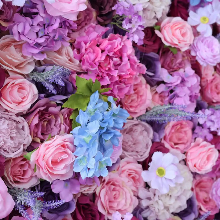 Close-up of pink, purple, and lavender roses in a floral wall backdrop.