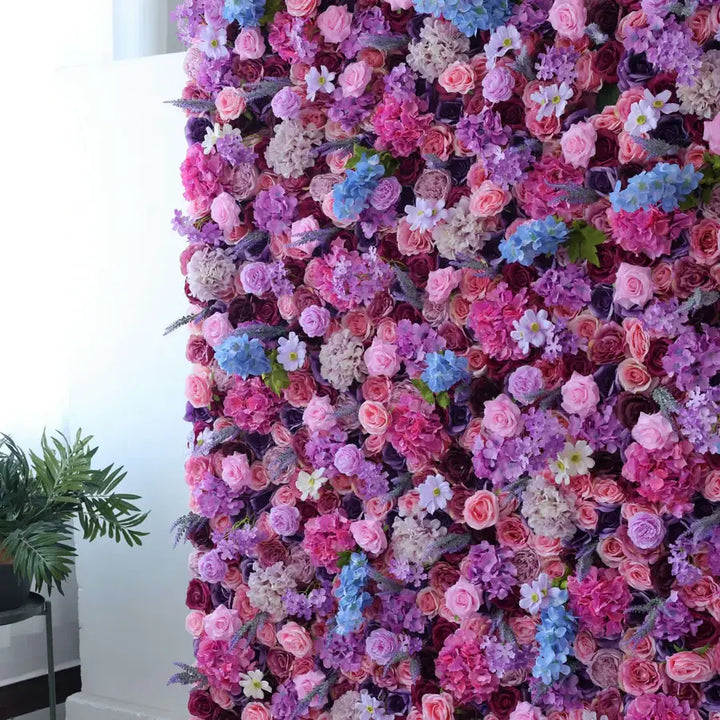 Floral wall backdrop with a beautiful mix of pink, purple, and lavender roses for weddings and events.