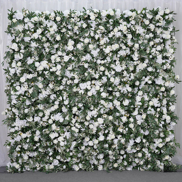 Elegant white floral wall backdrop with lush greenery for outdoor events.
