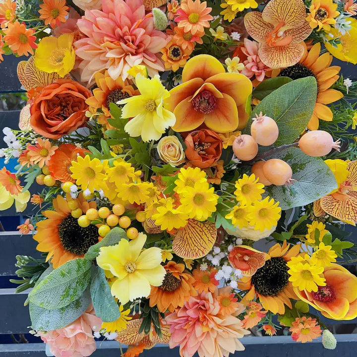 Full view of a bright and cheerful flower wall featuring sunflowers and orange blooms, perfect for any celebration.
