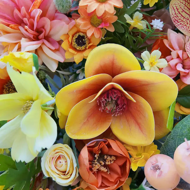 Vibrant orange floral wall backdrop with sunflowers, roses, and orchids for a lively wedding or party decoration.