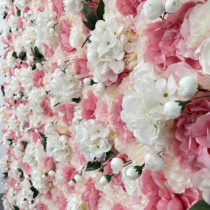 Close-up of a delicate pink and white flower wall backdrop featuring roses and soft greenery for events.