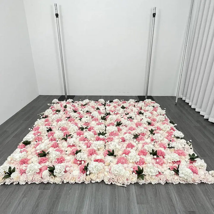 Close-up of a delicate pink and white flower wall backdrop featuring roses and soft greenery for events.