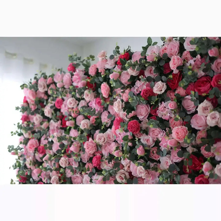 Close-up of a lush floral wall backdrop featuring a variety of roses in pink, red, and white, perfect for event decorations.