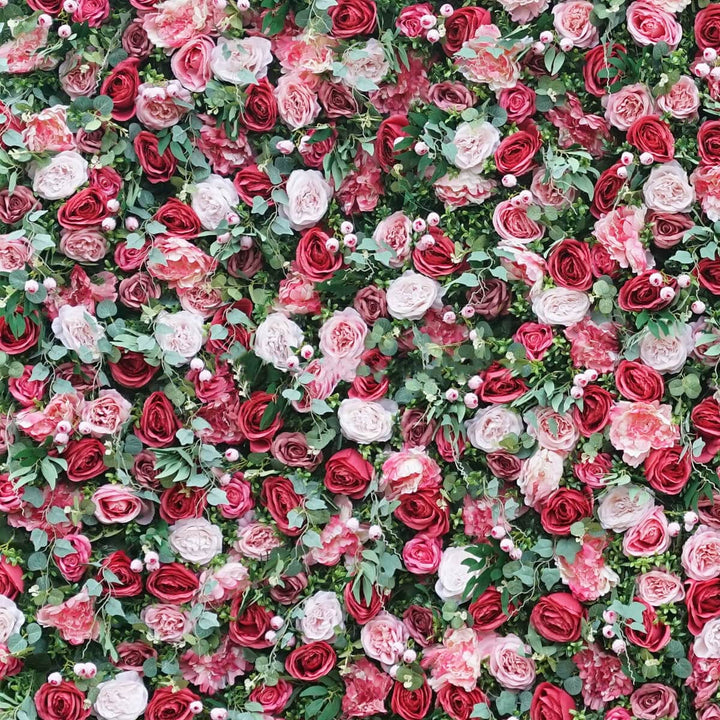 Stunning mix of red and blush roses on a lush green flower wall backdrop.
