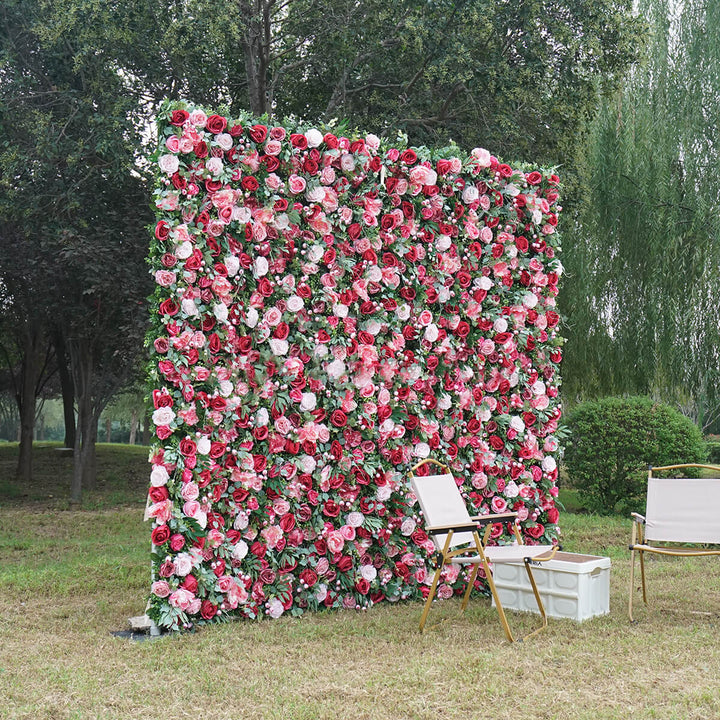 Elegant floral wall backdrop featuring vibrant red and blush roses with green foliage.
