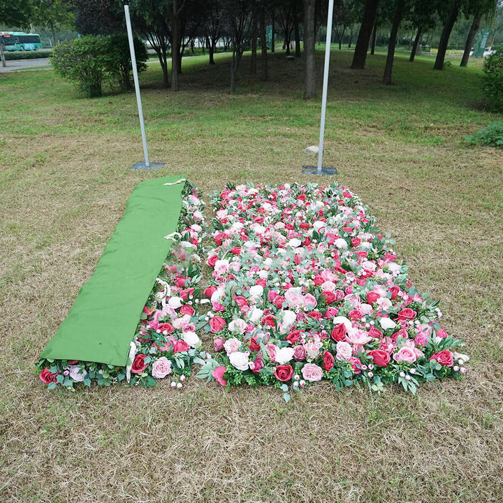 Stunning mix of red and blush roses on a lush green flower wall backdrop.
