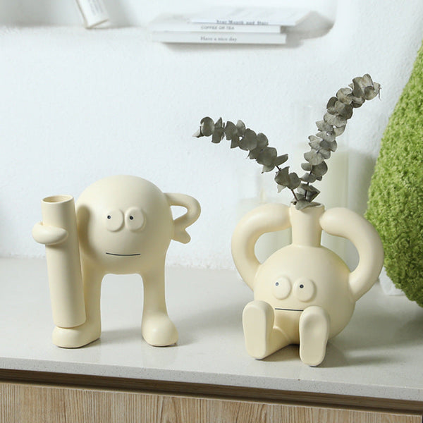 Playful cream-colored ceramic character vases on display