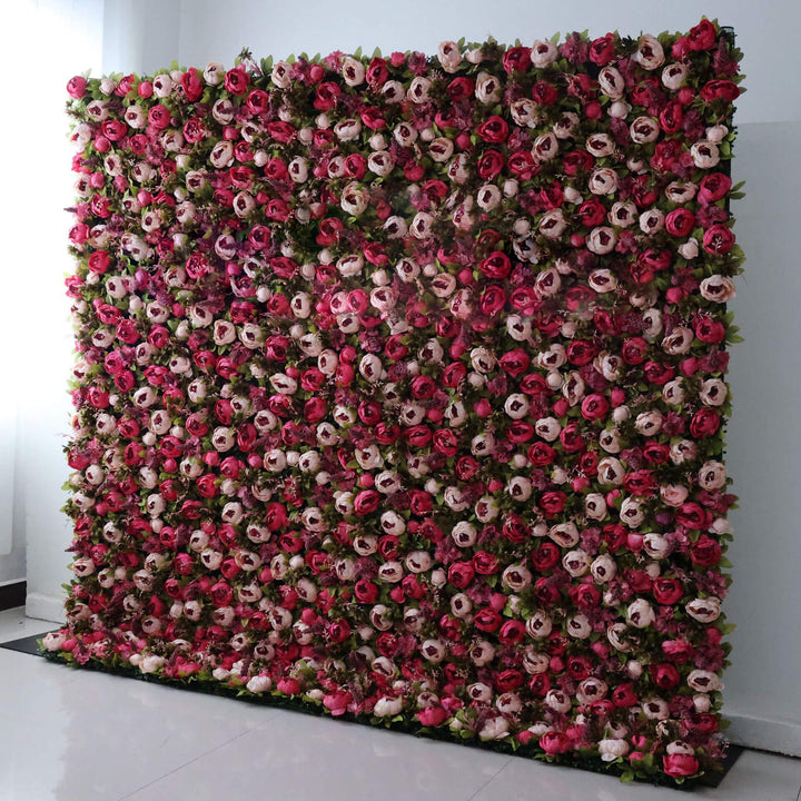 Luxurious red and blush rose arrangement on a decorative flower wall backdrop.
