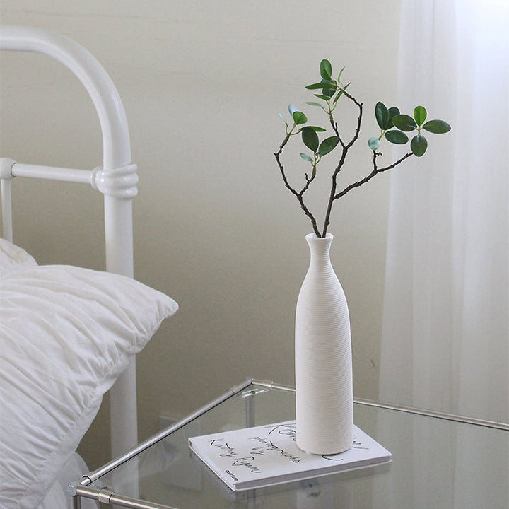 Tall and short white ceramic vases on wooden surface