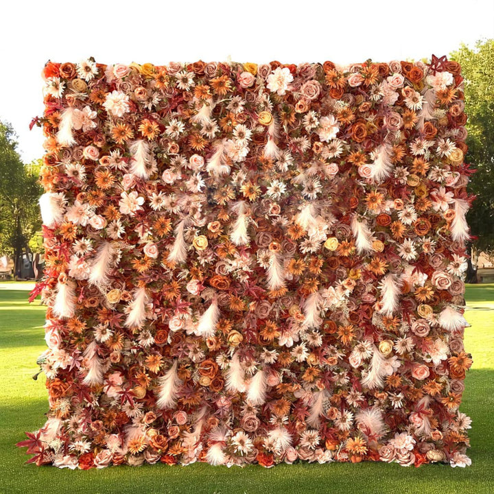 autumn-themed flower wall backdrop with rich oranges and pampas grass.
