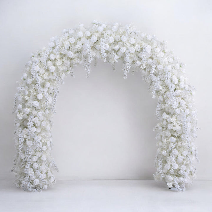 Stunning white floral arch with cascading roses and delicate accents, creating an elegant and timeless backdrop for weddings and special events.