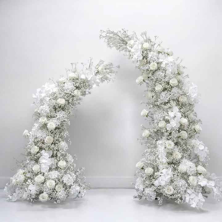 Elegant white floral wedding arch with roses and delicate baby's breath, perfect for creating a timeless and classic backdrop for weddings and sophisticated events.