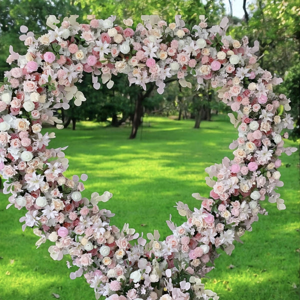 Heart-shaped floral backdrop featuring soft blush and white roses, creating a whimsical and romantic setting for outdoor weddings and special events.