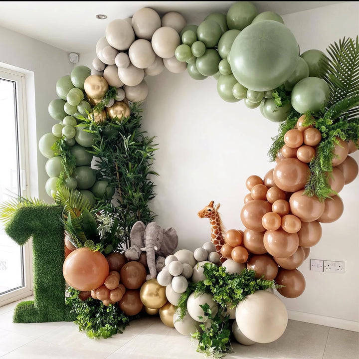 Jungle-inspired balloon garland in green, brown, and cream for safari party
