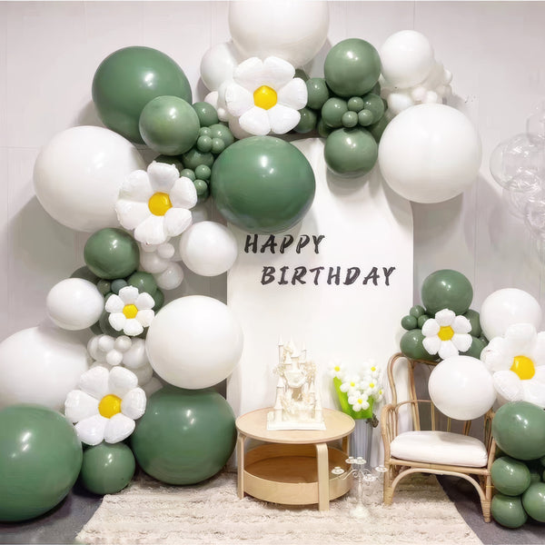 Green and white balloon arch with daisy accents for birthday party
