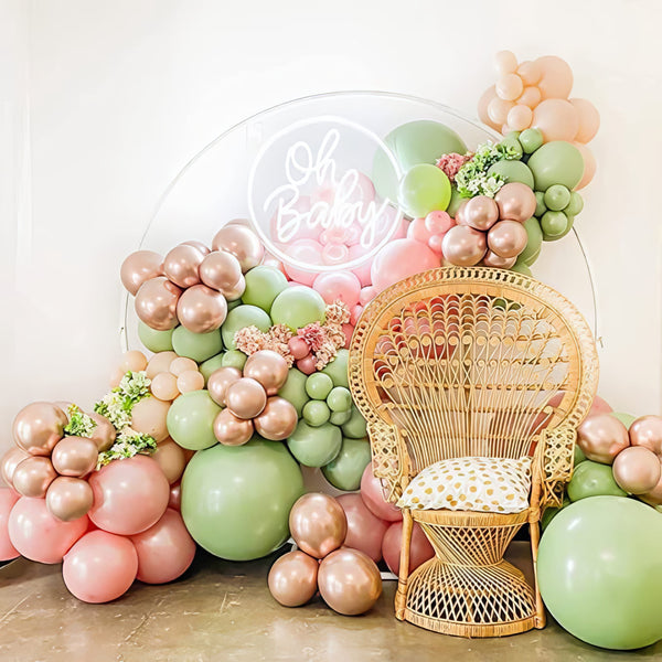 Soft pink and green balloon garland for elegant baby shower decor
