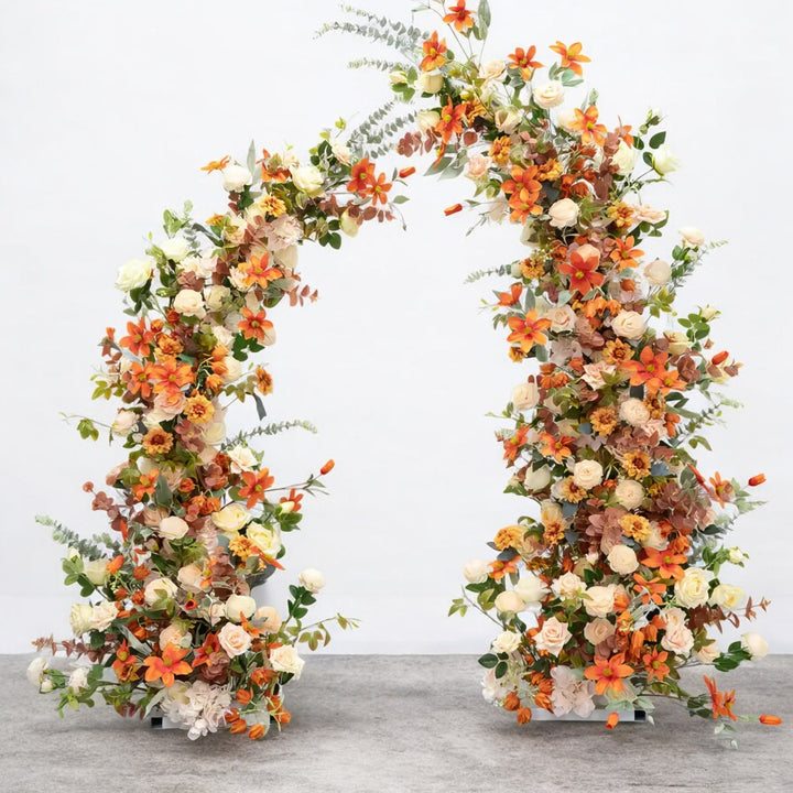 Vibrant floral arch featuring orange, cream, and blush flowers, creating a stunning statement piece for weddings and outdoor celebrations.