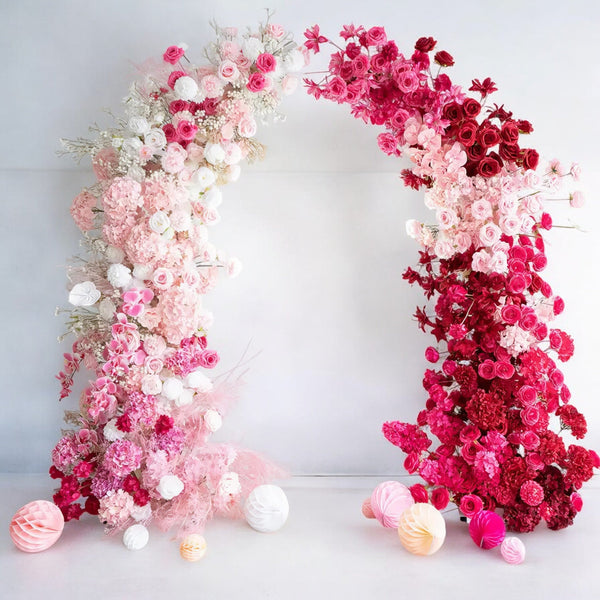 Stunning floral wedding arch in shades of pink, from blush to deep magenta, perfect for adding a vibrant and romantic touch to weddings and celebrations.