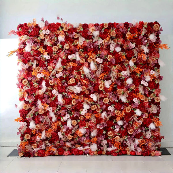 Autumn-themed flower wall backdrop with rich red, orange, and blush blooms for weddings and events.