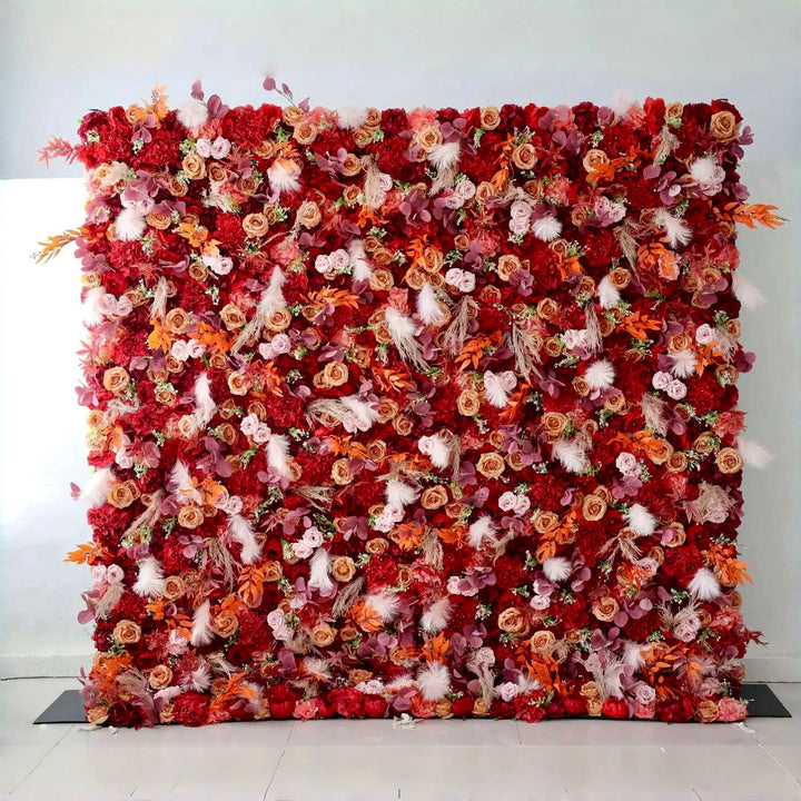 Autumn-themed flower wall backdrop with rich red, orange, and blush blooms for weddings and events.